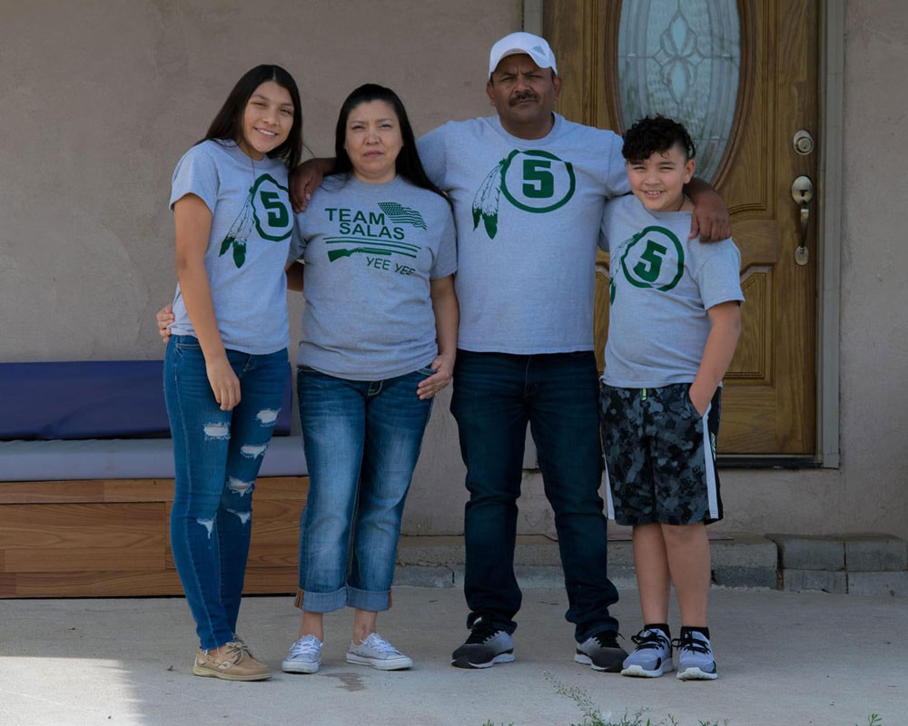 The Salas Family standing in front of their home